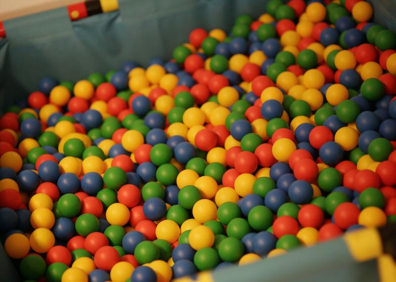 Viele bunte Bälle in einem Planschbecken ohne Wasser