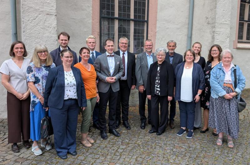 Viele Leute stehen in einem Halbkreis vor der Martkirche Lage